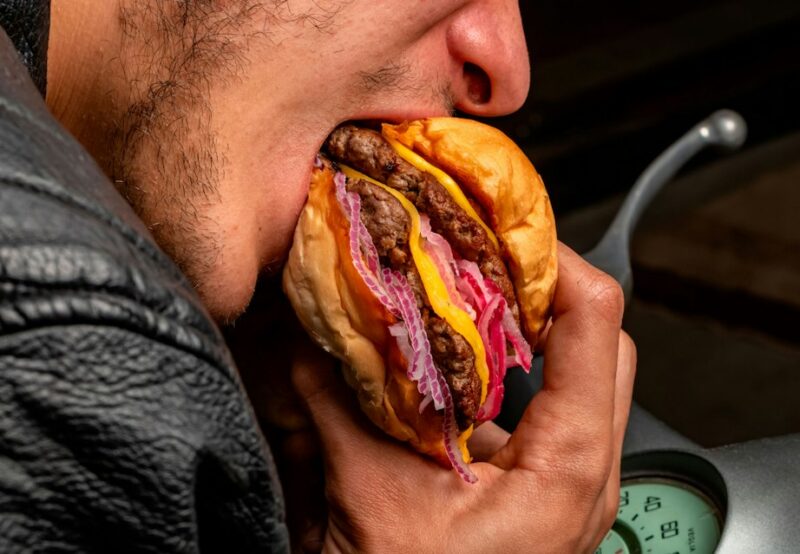 Mand spiser burger